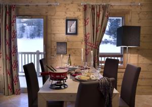 - une salle à manger avec une table et des chaises dans l'établissement CGH Résidences & Spas Les Chalets De Laÿssia, à Samoëns