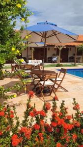 a table and chairs with an umbrella next to a pool at Belladora Pousada in Barra Grande