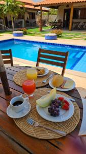 uma mesa com pratos de comida, café e frutas em Belladora Pousada em Barra Grande