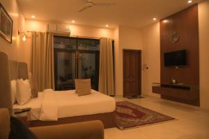 une chambre d'hôtel avec un lit et une télévision dans l'établissement The Elet Signature Boutique Hotel, à Karachi