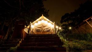Kim Ngan Hills Resort Da Lat. في Da Thien: خيمة بيضاء كبيرة مع سلالم في الليل