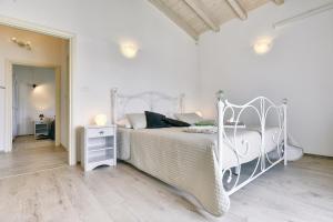 ein weißes Bett in einem weißen Schlafzimmer mit einem Nachttisch in der Unterkunft Family friendly house with a parking space Pula - 22733 in Pula