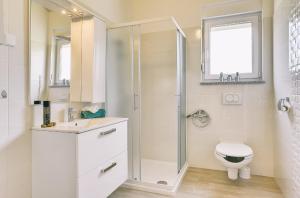 ein weißes Bad mit einer Dusche und einem WC in der Unterkunft Family friendly house with a parking space Pula - 22733 in Pula