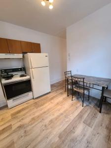 uma cozinha com um frigorífico branco e uma mesa com cadeiras em Private Parking III Full Kitchen III Room B em Montréal