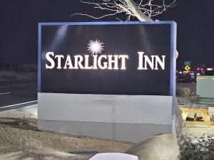 un cartello per una locanda di Starrett sul ciglio di una strada di Starlight Inn & Suites Motel 29 Palms Joshua Tree National Park a Twentynine Palms