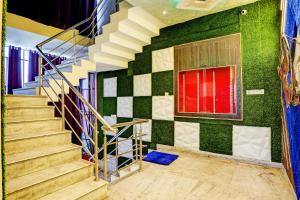 eine Treppe in einem Zimmer mit grünen Wänden und einem Fenster in der Unterkunft OYO ALASKA HOTEL in Alwar