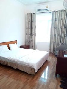 een slaapkamer met een bed en een raam bij Amazon Hotel in Vinh