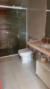 uma casa de banho com um WC, um chuveiro e um lavatório. em Belladora Pousada em Barra Grande