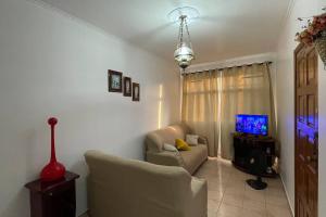 een woonkamer met een bank en een tv bij desativado in São Vicente