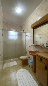 een badkamer met een douche, een toilet en een wastafel bij desativado in São Vicente