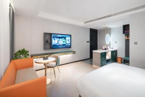 a bedroom with a bed and a tv on a wall at R Royalss Hotel, Chengdu Chunxi Road Taikooli Tianfu in Chengdu