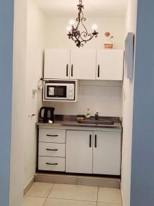 a kitchen with white cabinets and a microwave at -AMBIENTE BOTIQUE- Tu lugar ideal- in Santiago del Estero