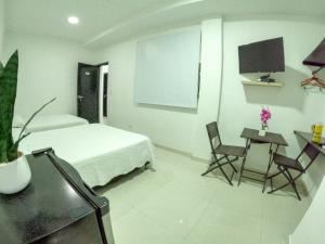 a bedroom with a bed and a table and chairs at Hotel Almendros in San Andrés