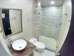 y baño con aseo, lavabo y ducha. en Hotel Almendros, en San Andrés