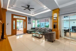 een woonkamer met een bank en een tafel bij Gala Villa Pattaya in Pattaya South