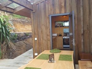 a wooden house with a table and a kitchen at Yurt retreat in Pangatotara