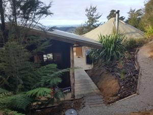 a house on a hill with a wooden walkway at Yurt retreat in Pangatotara +10 photos