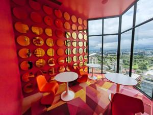 a room with tables and chairs and a large window at 804 SECRT Sabana Hermoso Apartamento con Aire Acondicionado in San José