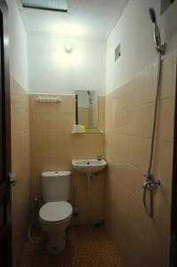 a small bathroom with a toilet and a sink at Andrea Hotel in Yogyakarta