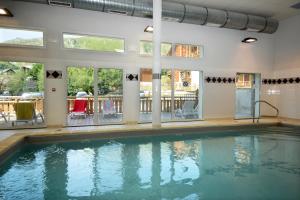 a swimming pool in a house with windows at Résidence Odalys Les Bergers in Saint-Sorlin-dʼArves