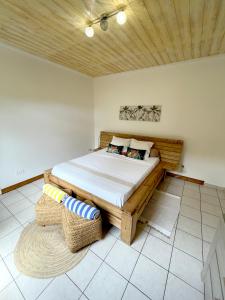 1 dormitorio con 1 cama y 1 silla de mimbre en La Bitasyon Tirisyl, en Capesterre