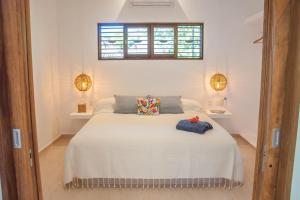 a bedroom with a white bed with two pillows on it at Casa Mon Repos en Careyes in Careyes