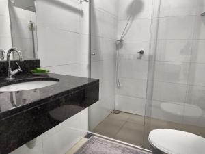 a bathroom with a shower and a sink and a toilet at Loft Carminatti in Cacoal +60 photos