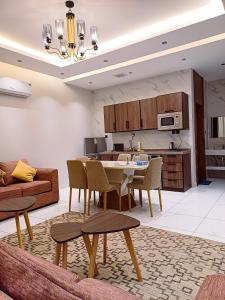 un soggiorno con tavolo e sedie e una cucina di فلل بيات الفيصل Bayat Al Faisal Villas a Baljurashi