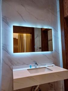 La salle de bains est pourvue d'un lavabo et d'un miroir. dans l'établissement فلل بيات الفيصل Bayat Al Faisal Villas, à Baljurashi