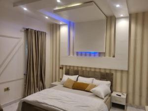um quarto com um grande espelho por cima de uma cama em Shagari Estate Prestige 3-Bedroom Apartments. em Lagos