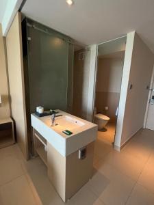 ein Badezimmer mit einem Waschbecken, einem Spiegel und einem WC in der Unterkunft Cam Ranh Sea View apeartment Nha Trang in Cam Ranh