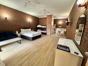 Habitación de hotel con cama y sala de estar. en Knotts Crossing Resort en Katherine