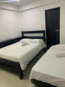 a bedroom with two beds and a black cabinet at Hotel Las Gaviotas in San Andrés