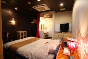 um quarto com uma cama e uma mesa com uma mesa de cabeceira em Hotel Mori no Komichi em Fukuchiyama