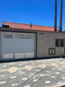 a pair of garage doors on a building at Casa Térrea - Nova Itanhaém in Itanhaém