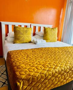 1 dormitorio con 1 cama con pared de color naranja en Lavender Lodge, en Mthatha