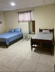 1 Schlafzimmer mit 2 Betten und einem Wandspiegel in der Unterkunft Casa de Emilia in Santa Ana