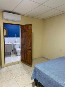 ein Schlafzimmer mit einem Bett und ein Badezimmer mit einem WC in der Unterkunft Casa de Emilia in Santa Ana