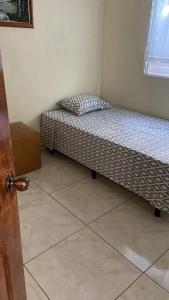 un piccolo letto in una camera con un comodino. di Casa de Emilia a Santa Ana