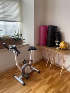 a room with a exercise bike and a table at Spacious flat next to central station in Glasgow