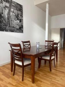 a dining room table with four chairs and a painting at Spacious flat next to central station in Glasgow
