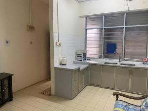 a kitchen with a counter and a window in it at CLP Perai Homestay Apartment in Chai Leng park in Perai