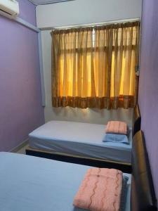 a small room with two beds and a window at CLP Perai Homestay Apartment in Chai Leng park in Perai