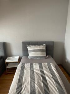 a bedroom with a bed with a striped comforter at Apartment groß 4 Zimmer in Essen +9 photos