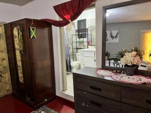 a bathroom with a dresser and a large mirror at Nine Miles Cultural Hangouts and Tours in Stepney