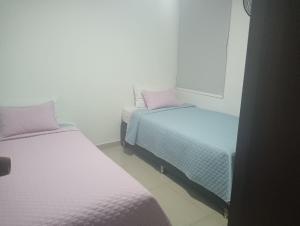 two beds in a small room with at Apartamentos Turísticos en Laureles- Estadio, Medellin in Medellín