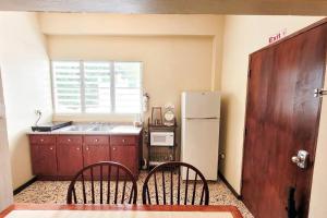 a kitchen with a sink and a refrigerator at Jayuya Cozy Aparment with Wi-Fi, Free Parking and AC in Jayuya