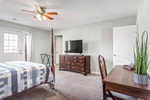 1 dormitorio con cama, mesa y TV en Renovated 3BR Retreat with Large Patio & Grill, en Charlotte
