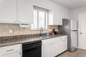 a kitchen with white cabinets and a stainless steel refrigerator at Renovated 3BR Retreat with Large Patio & Grill in Charlotte
