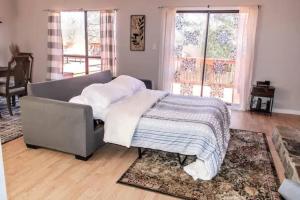 ein Bett mit einer Decke in einem Zimmer mit Fenstern in der Unterkunft Renovated 3BR Retreat with Large Patio & Grill in Charlotte